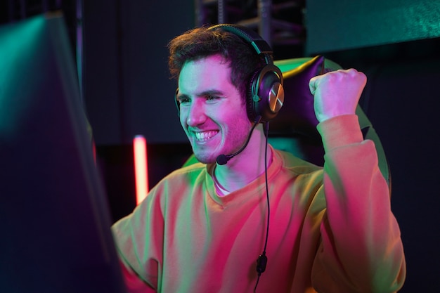 Medium shot happy gamer at desk