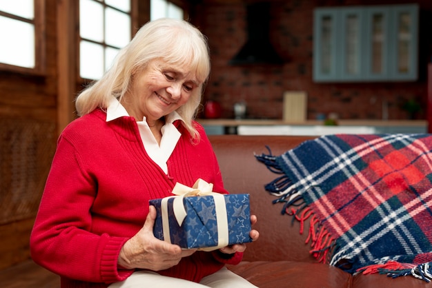 Medium shot happy grandma holding a gift