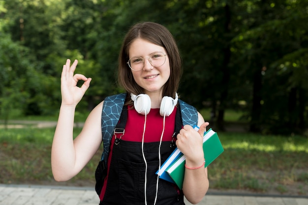 Free photo medium shot of happy highschool girl holding books in hands