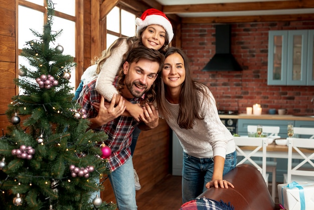 Medium shot happy parents and child posing indoors