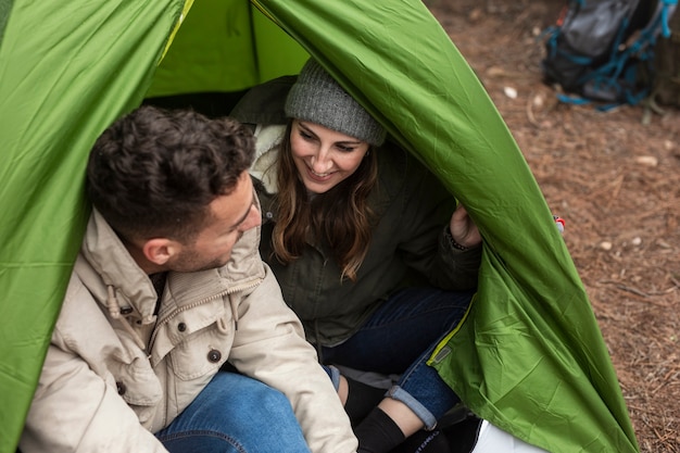 Medium shot happy people chatting in tent