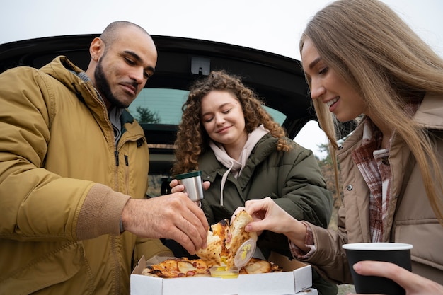 Free photo medium shot happy people with pizza