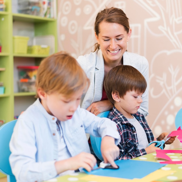 Medium shot happy teacher watching kids