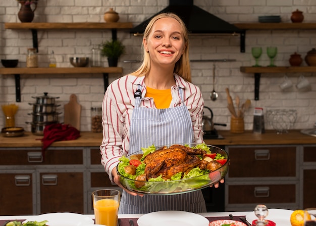 Free photo medium shot of happy woman holding a turkey