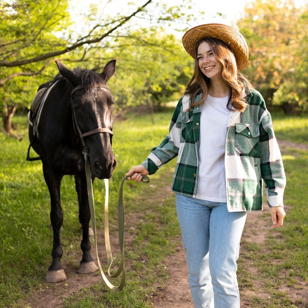 Medium shot happy woman and horse outdoors