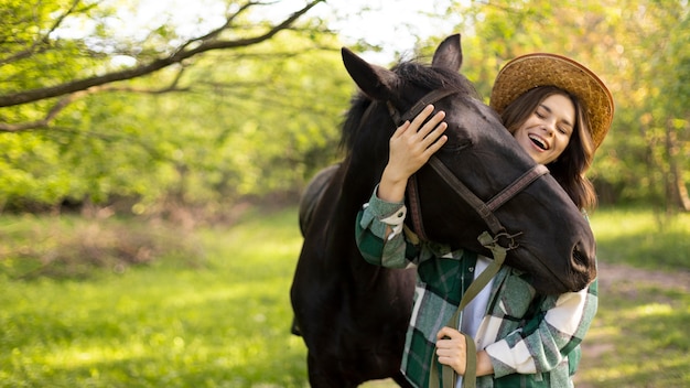 Medium shot happy woman and horse