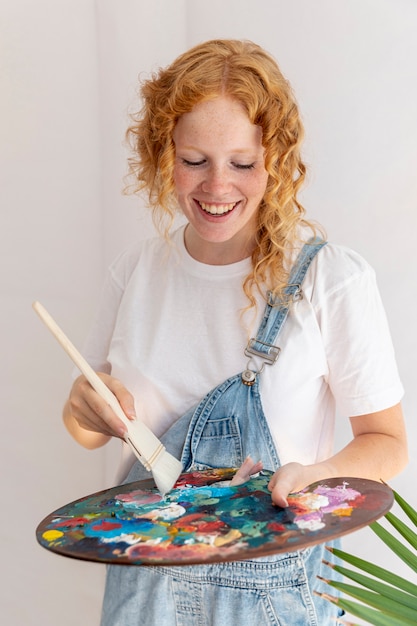 Medium shot happy woman with painting palette