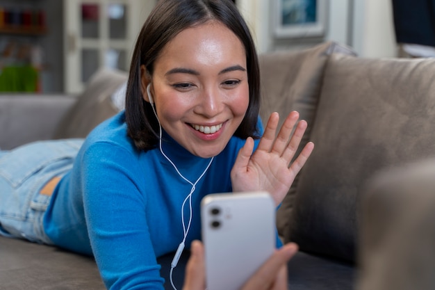 Medium shot happy woman with phone at home