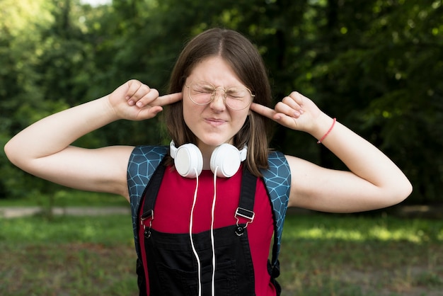 Free photo medium shot of highschool girl covering her ears