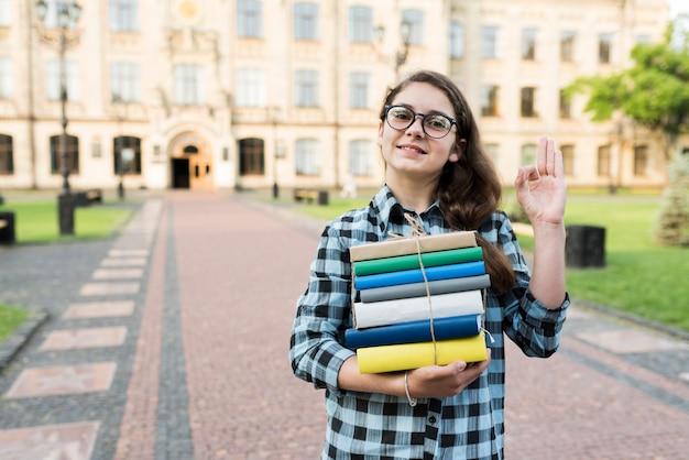 Free photo medium shot of highschool girl holding books in hands