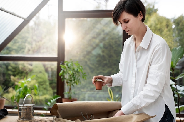 Free photo medium shot holding small potted plant