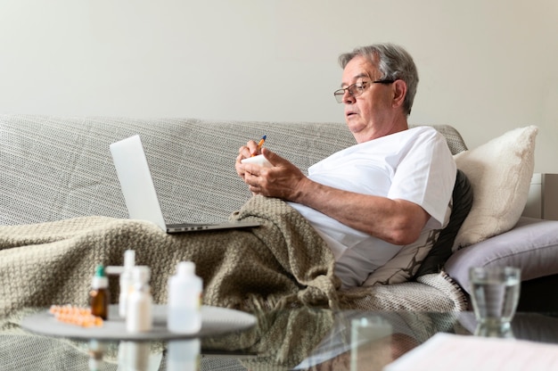 Medium shot ill man sitting on couch