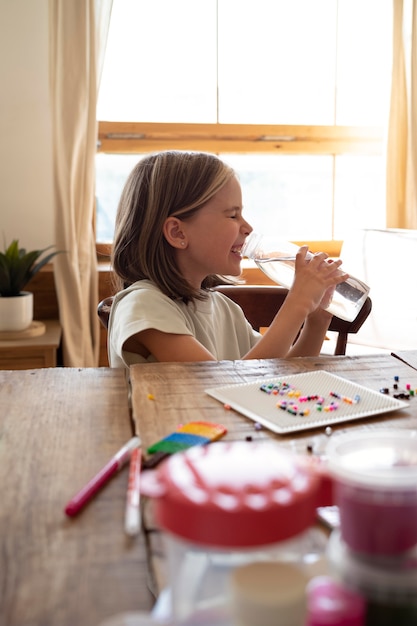 Medium shot kid drinking water from bottle