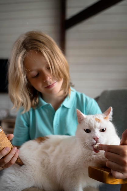 Medium shot kid feeding cat