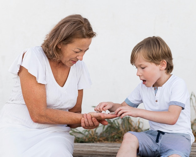 Medium shot kid and grandma with shells