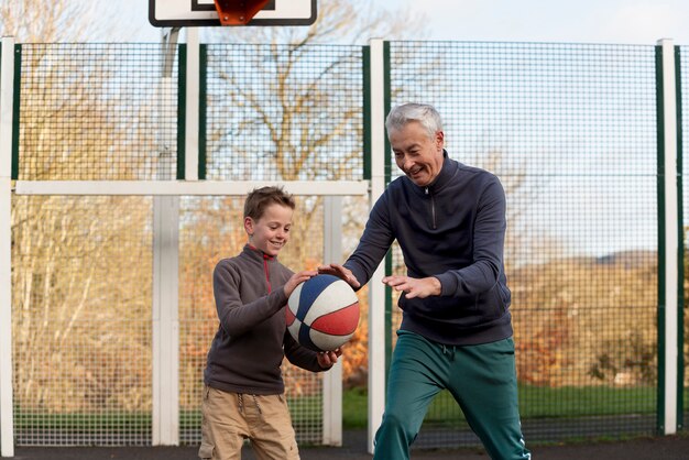 Medium shot kid and grandpa playing game