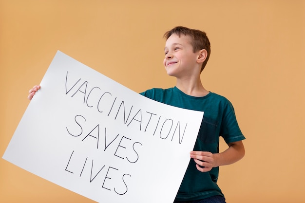 Free Photo medium shot kid holding placard