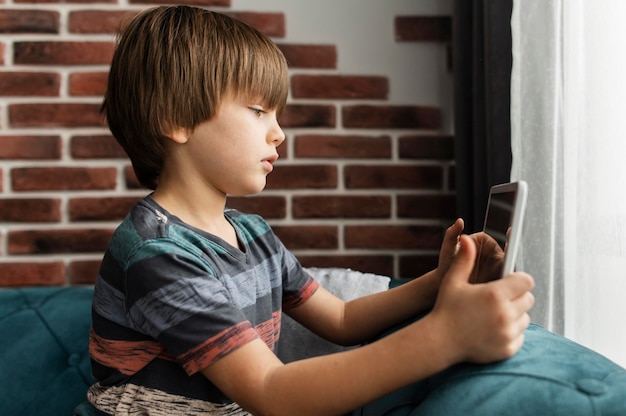 Medium shot kid holding tablet