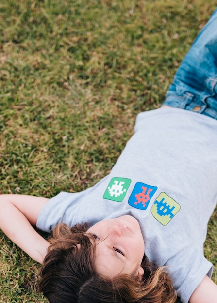 Free photo medium shot of kid lying on grass