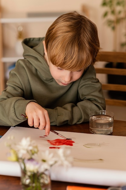 Free Photo medium shot kid painting with red