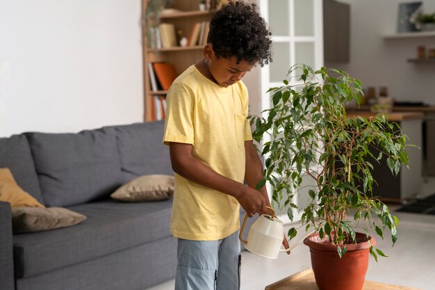 Medium shot kid watering plant