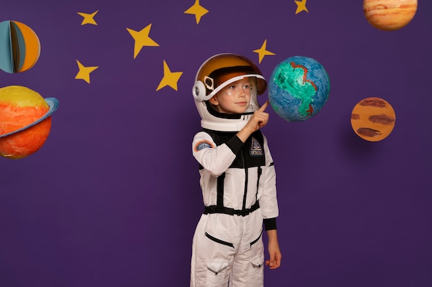 Free photo medium shot kid wearing spacesuit