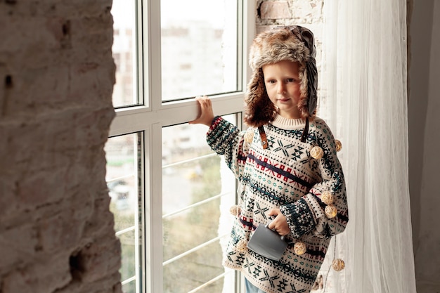 Free photo medium shot kid with hat and mug posing