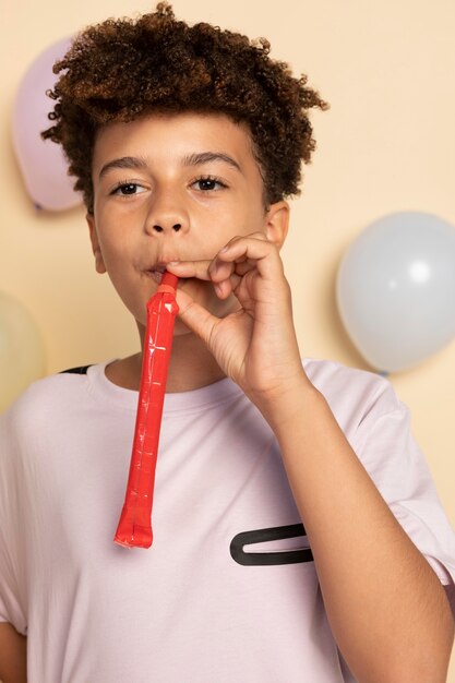 Medium shot kid with party whistle