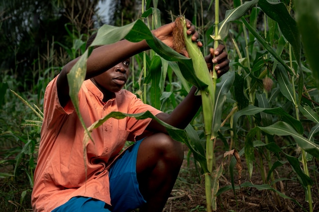 Medium shot kid working in the cornfield