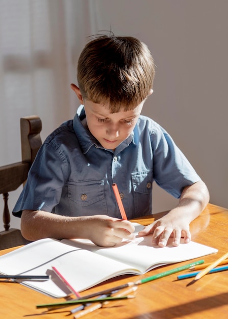 Medium shot kid writing on notebook