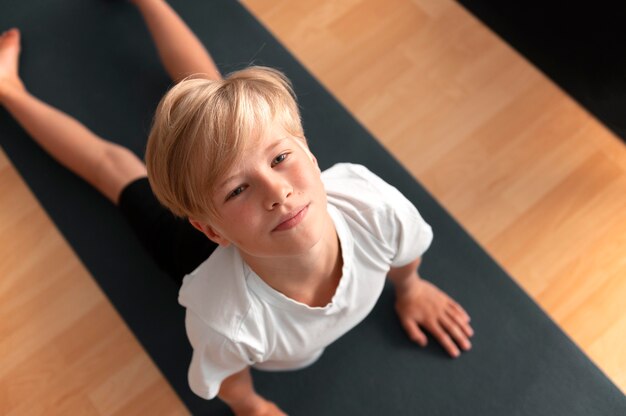 Medium shot kid on yoga mat