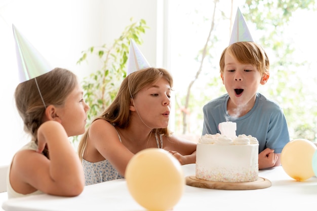 Free Photo medium shot kids blowing candle