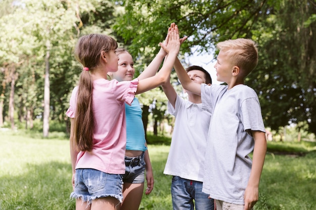 Medium shot kids high fiving before a match