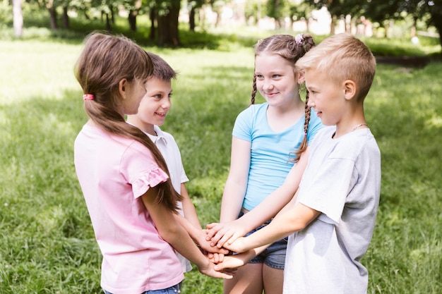 Free photo medium shot kids holding their hands together