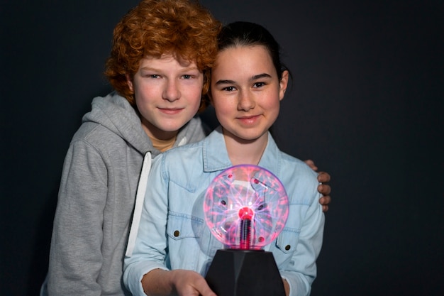 Free Photo medium shot kids interacting with a plasma ball