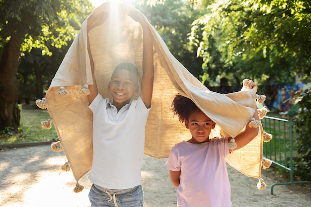 Medium shot kids playing with blanket