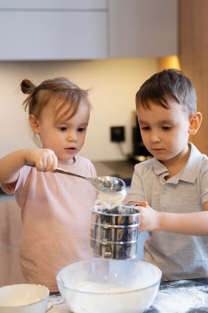 Medium shot kids pouring flour