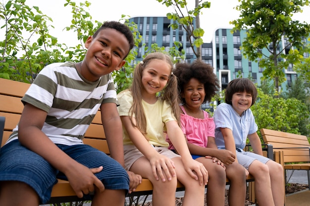 Free Photo medium shot kids sitting on bench