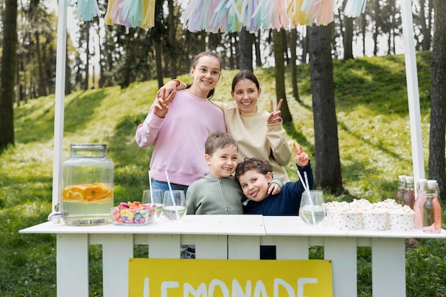 Free photo medium shot kids with lemonade stand