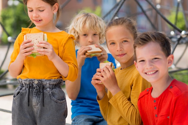 Free photo medium shot kids with sandwiches