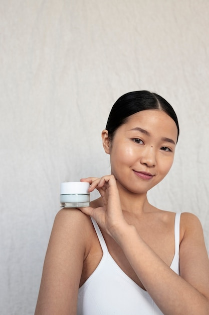 Medium shot korean woman posing with face cream