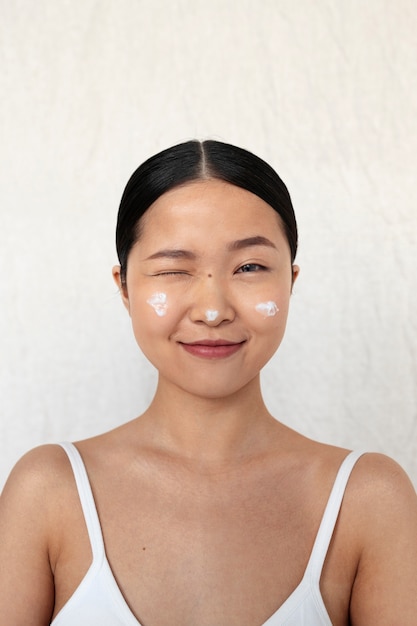 Medium shot korean woman posing with face cream