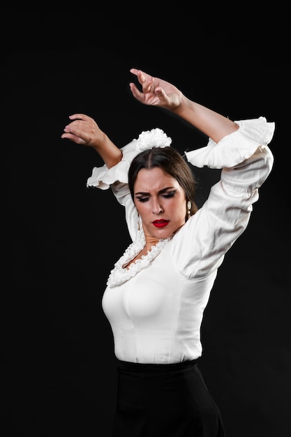 Free Photo medium shot lady performing flamenco dance with arms up