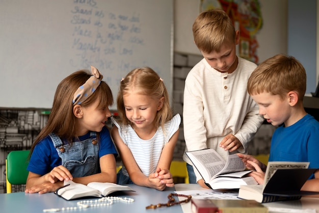 Medium shot little kids studying bible