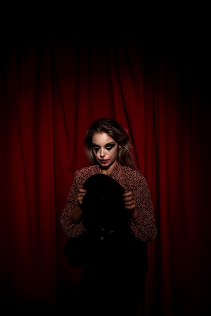 Free Photo medium shot of make-up woman clown holding a hat