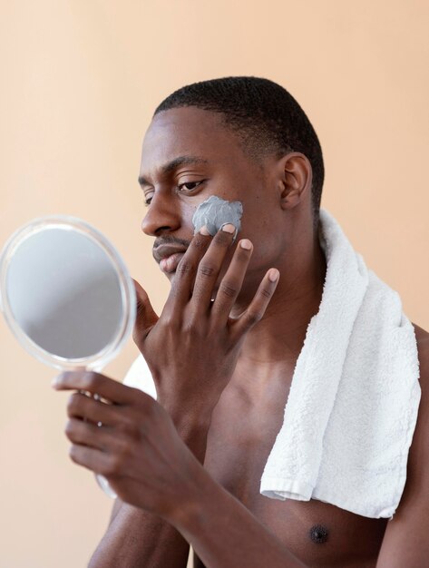 Medium shot man applying face treatment