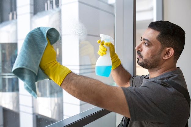 Free photo medium shot man cleaning office window