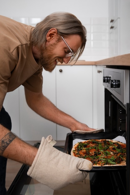 Free photo medium shot man cooking pizza