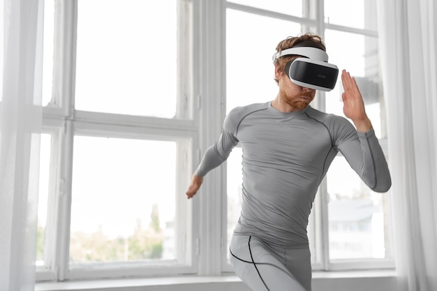 Free photo medium shot man doing fitness with vr glasses