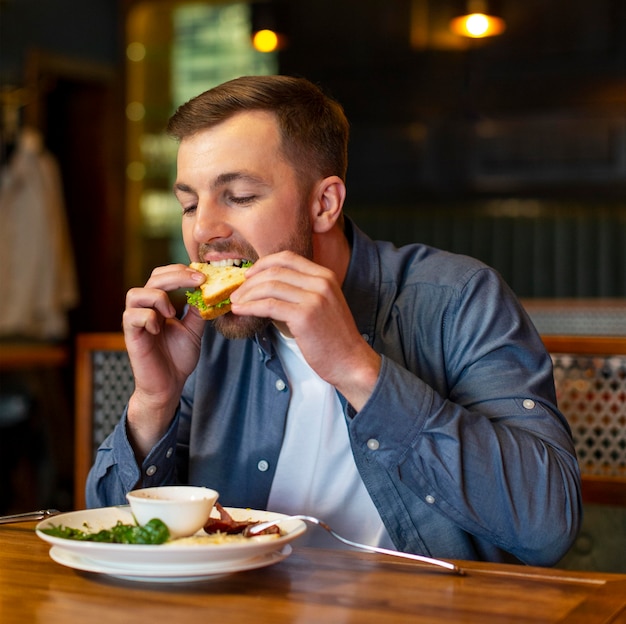 Medium shot man eating indoors